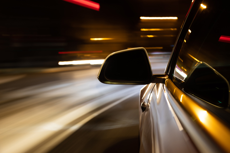 Car light trail while driving in the coty by night